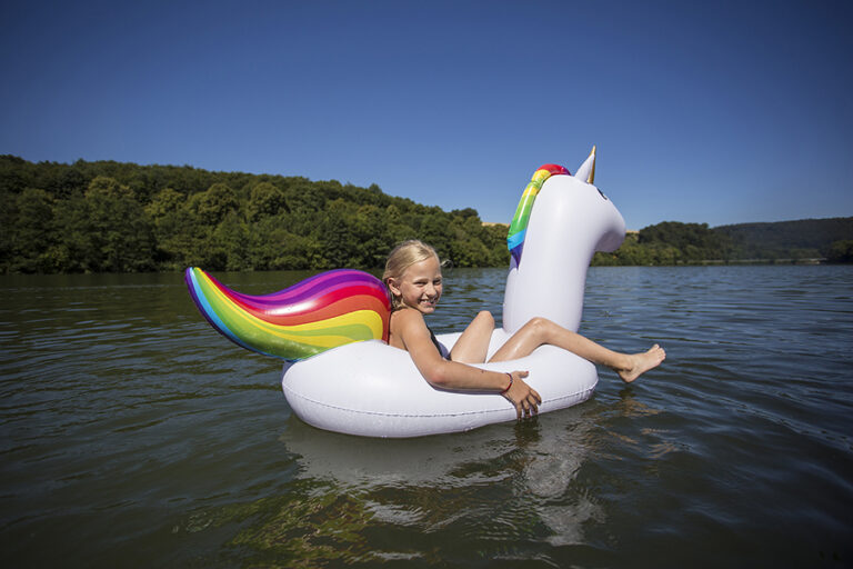 Ein Kind auf einem Wasserspieltier auf dem Hennesee.